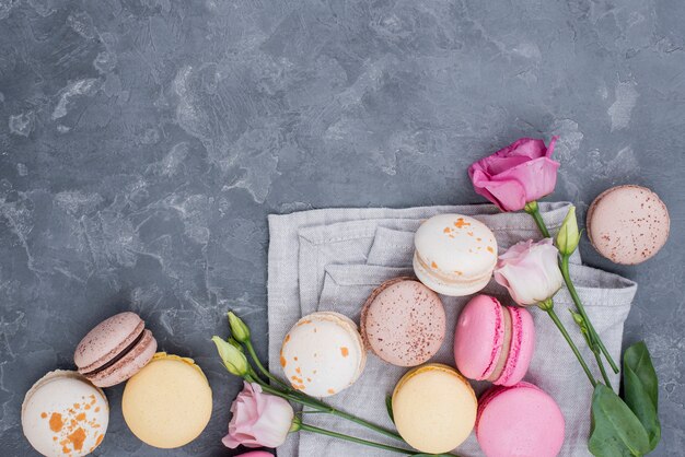 Vista dall'alto di deliziosi macarons con rose e copia spazio