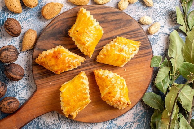 Vista dall'alto di deliziosi pasticcini dolci con noci sulla superficie blu