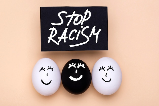Vista dall'alto di diverse uova colorate con facce per vite nere movimento importa con fermare il razzismo