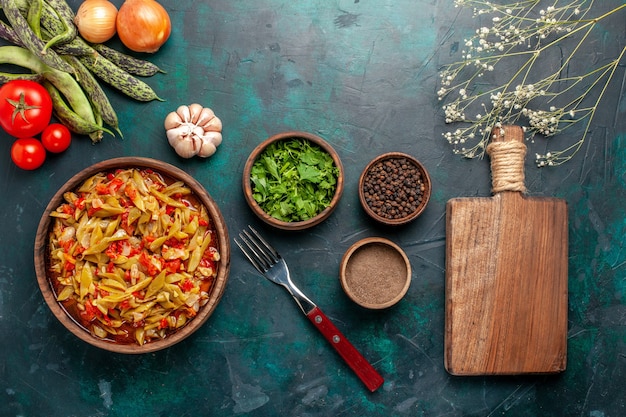 Vista dall'alto di farina di verdure a fette con diversi ingredienti e condimenti su sfondo blu scuro