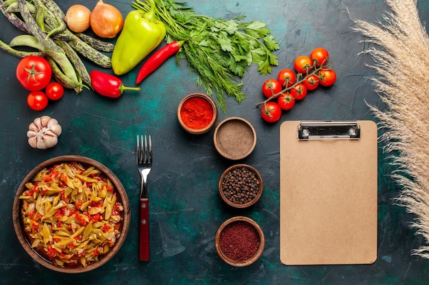 Vista dall'alto di farina di verdure a fette con diversi ingredienti e condimenti su sfondo blu scuro