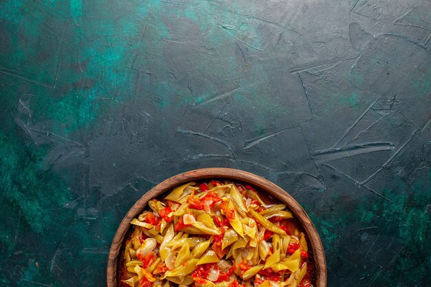 Vista dall'alto di farina di verdure a fette cucinata con diversi ingredienti su sfondo blu