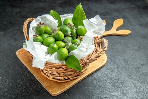 Vista dall'alto di feijoas verdi freschi naturali con foglie in un cestino wricked