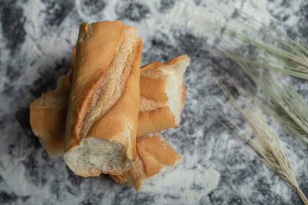 Vista dall'alto di fette di baguette appena sfornate su sfondo bianco.