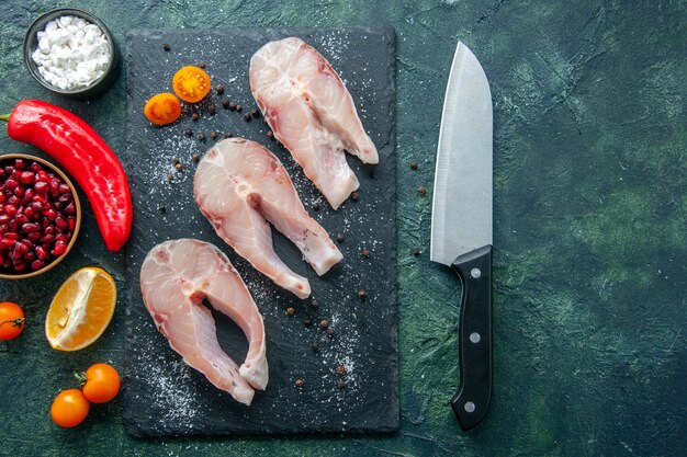 Vista dall'alto di fette di pesce fresco su sfondo scuro frutti di mare oceano carne pasto piatto insalata acqua pepe cibo