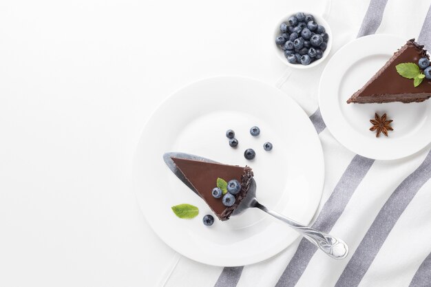 Vista dall'alto di fette di torta al cioccolato su piastre con mirtilli