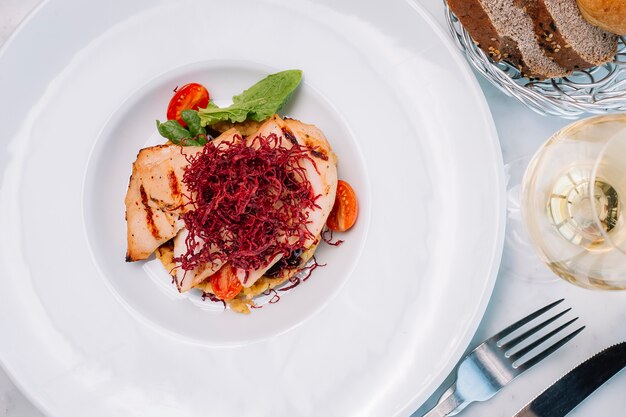 Vista dall'alto di filetto di pollo alla griglia servito con bulgur e verdure e vino bianco