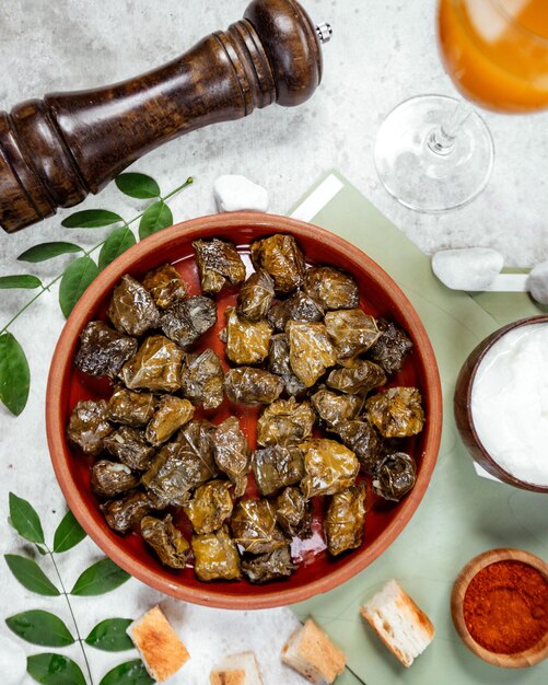 Vista dall'alto di foglie di vite azero dolma in padella di ceramica servito con yogurt