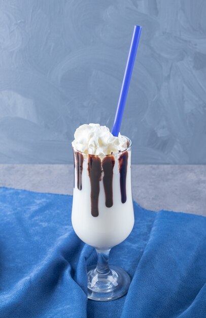 Vista dall'alto di frappè al cioccolato su sfondo blu.