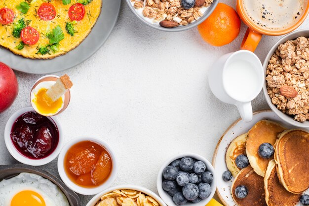 Vista dall'alto di frittelle e frittata con marmellata e mirtilli per la colazione