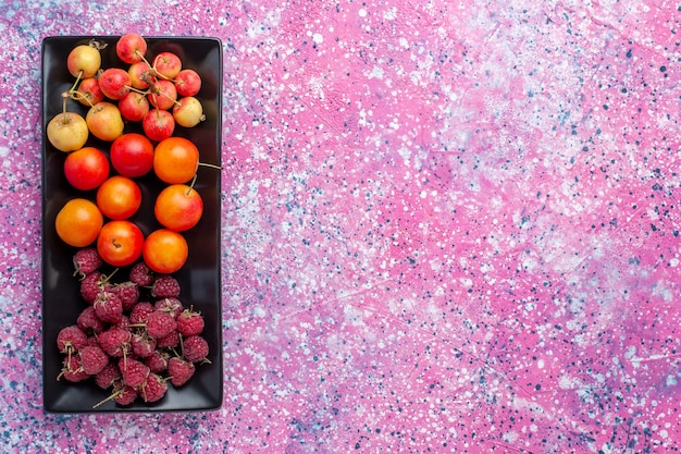 Vista dall'alto di frutta fresca all'interno del modulo nero sulla superficie rosa