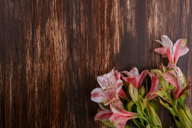 Vista dall'alto di gigli rosa su una superficie di legno