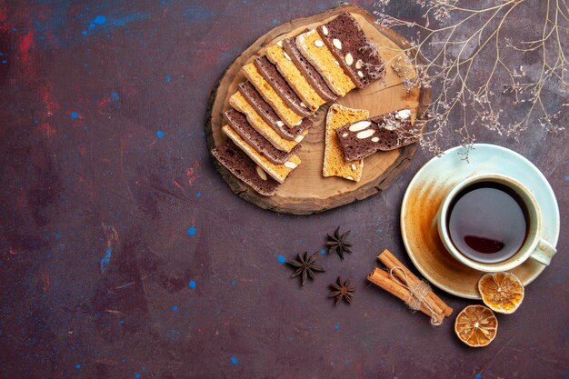 Vista dall'alto di gustose fette di torta con noci e tazza di tè su nero