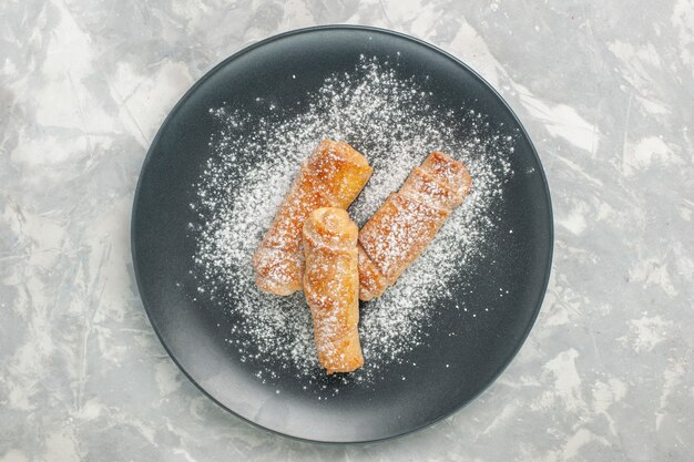 Vista dall'alto di gustosi bagel dolci di zucchero a velo sulla superficie bianca