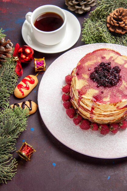 Vista dall'alto di gustosi pancake alla frutta con una tazza di tè al buio