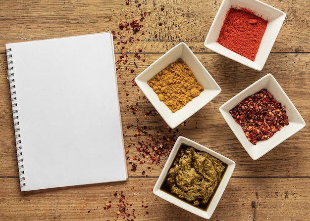Vista dall'alto di ingredienti alimentari con taccuino e spezie