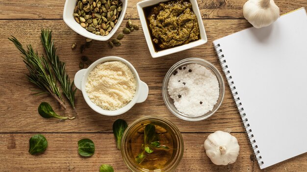 Vista dall'alto di ingredienti alimentari con taccuino ed erbe aromatiche