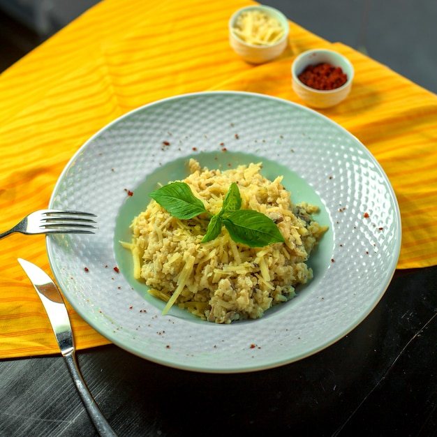 Vista dall'alto di insalata di verdure con funghi noci e formaggio servito con salsa di panna in un piatto bianco