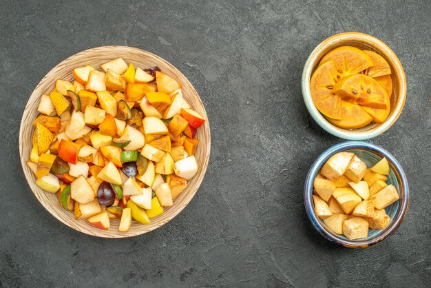 Vista dall'alto di insalata fruttata con frutta a fette su sfondo grigio