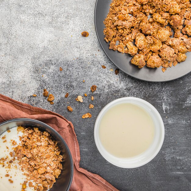 Vista dall'alto di latte biologico con muesli sul tavolo