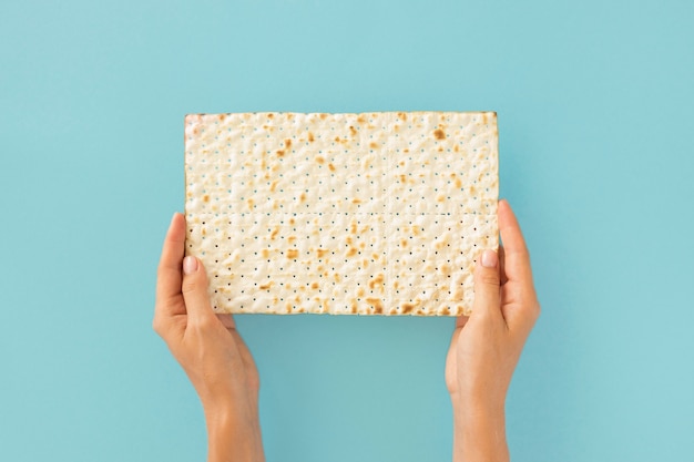 Vista dall'alto di mani che tengono il cracker ebraico