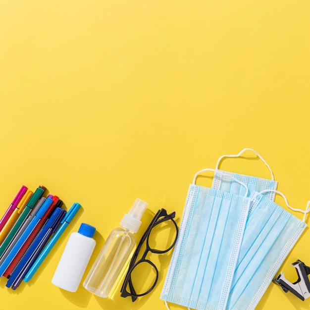 Vista dall'alto di materiale scolastico con matite e disinfettante per le mani