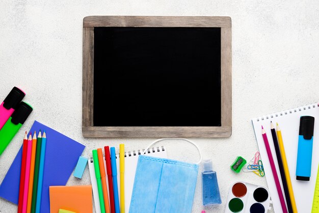 Vista dall'alto di nuovo a materiale scolastico con lavagna e matite