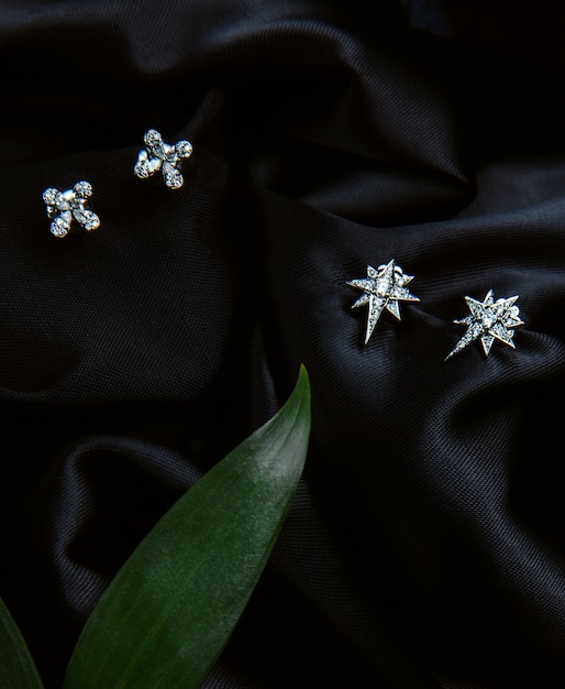 Vista dall'alto di orecchini in argento sterling con diamanti con borchie su parete nera