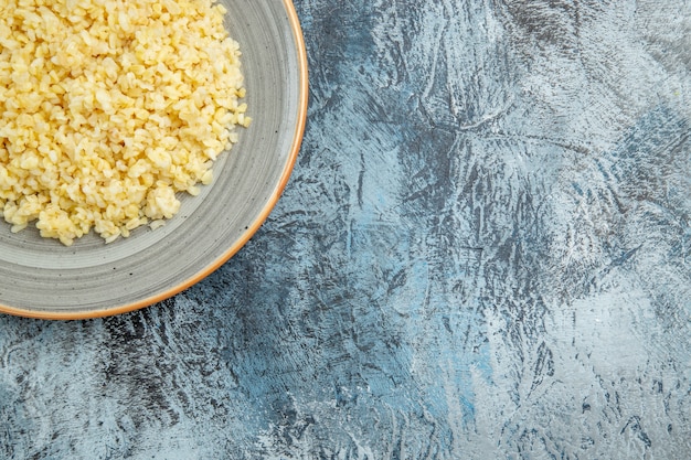 Vista dall'alto di orzo perlato cotto all'interno della piastra sulla superficie chiara