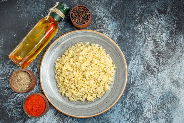 Vista dall'alto di orzo perlato cotto con condimenti sulla superficie chiara