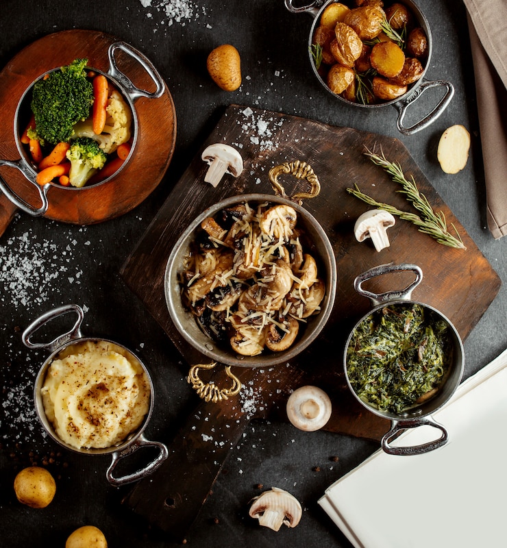 Foto gratuito vista dall'alto di padelle con sautee di funghi purè di patate sabzi verdure bollite e patate arrosto