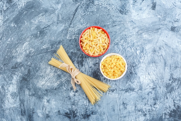 Vista dall'alto di pasta assortita in ciotole su sfondo grigio intonaco. orizzontale