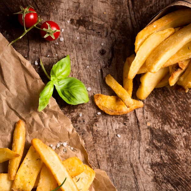 Vista dall'alto di patatine fritte con erbe e pomodori