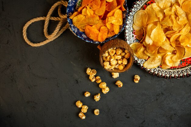 Vista dall'alto di patatine fritte e popcorn in un piatto con motivo orientale sul nero