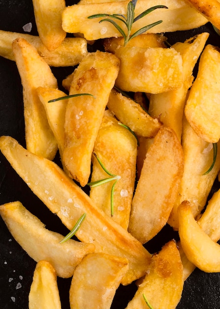 Vista dall'alto di patatine fritte salate con erbe aromatiche