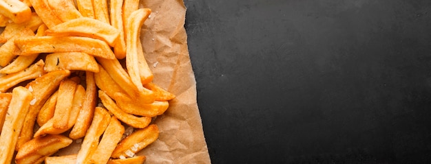 Vista dall'alto di patatine fritte su carta con copia spazio