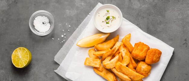 Vista dall'alto di patatine fritte sulla piastra con salsa e sale