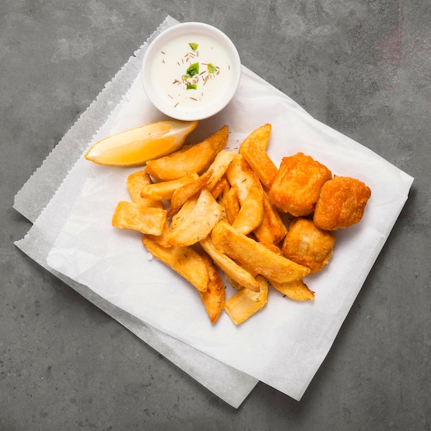 Vista dall'alto di patatine fritte sulla piastra con salsa speciale