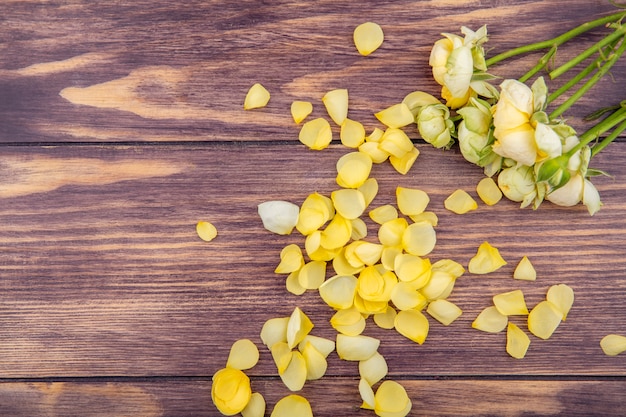 Vista dall'alto di peonie meravigliose e fresche con petali gialli su una superficie di legno