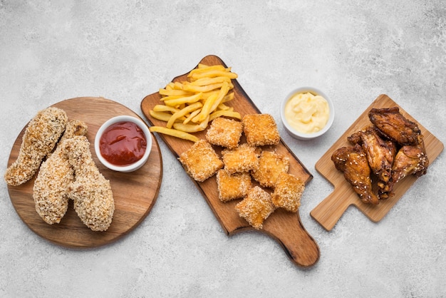 Vista dall'alto di pepite di pollo fritto e salse sui taglieri