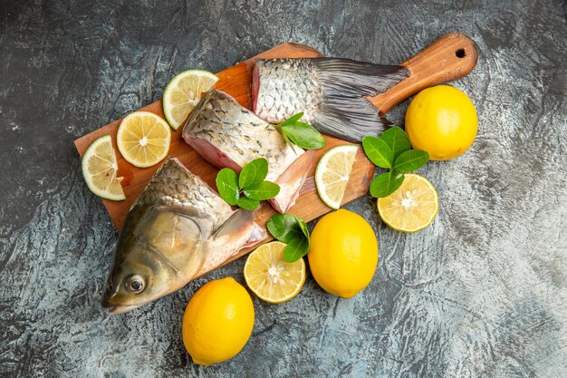 Vista dall'alto di pesce fresco a fette con il limone sulla superficie chiara