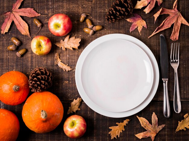 Vista dall'alto di piatti per la cena del ringraziamento con foglie d'autunno