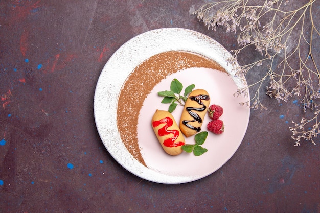 Vista dall'alto di piccoli biscotti dolci all'interno del piatto progettato su nero