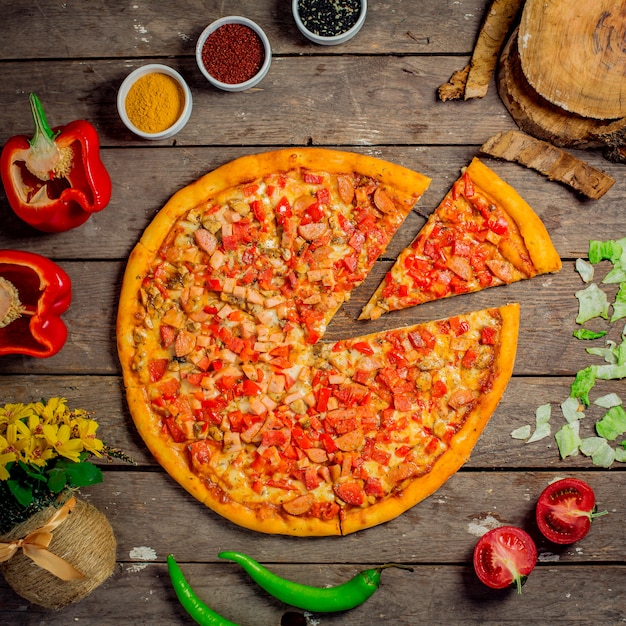 Vista dall'alto di pizza con verdure tritate funghi e salsicce a fette