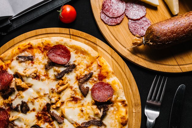 Vista dall'alto di pizza di carne mista con salame piccante, pollo e manzo