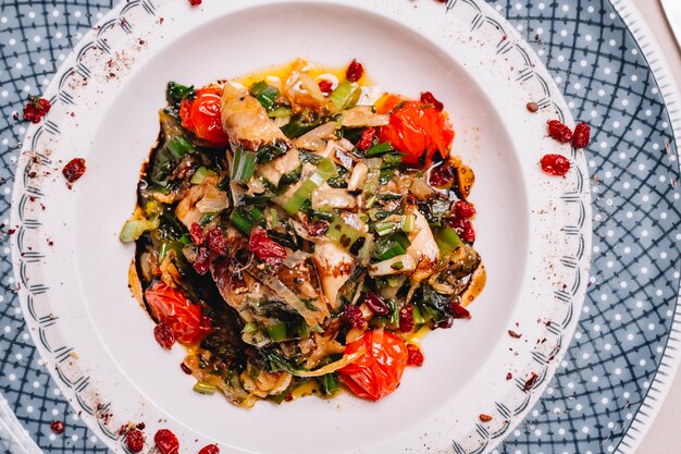 Vista dall'alto di pollo alla griglia con peperone cipolla pomodoro verde e verdure su un piatto