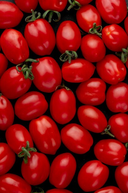 Vista dall'alto di pomodori ciliegia maturi su sfondo nero