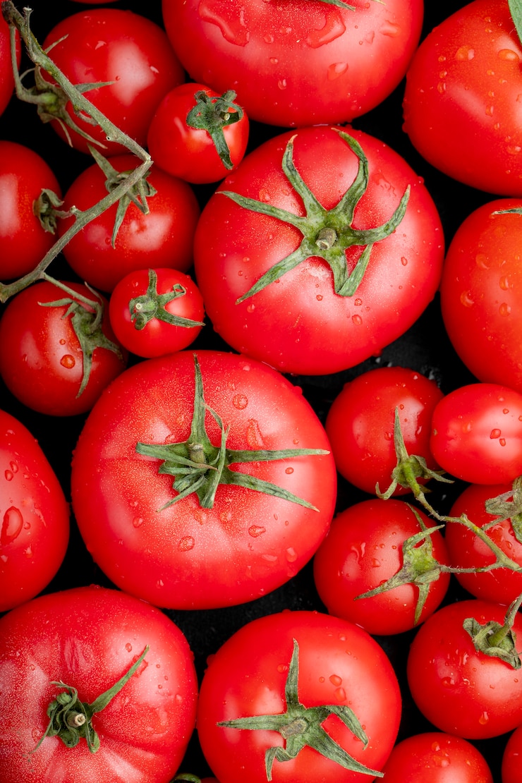 Foto gratuito vista dall'alto di pomodori freschi maturi con gocce d'acqua su sfondo nero