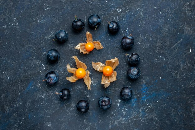 vista dall'alto di prugnoli freschi allineati in cerchio sulla scrivania scura, frutta fresca bacche cibo vitamina salute