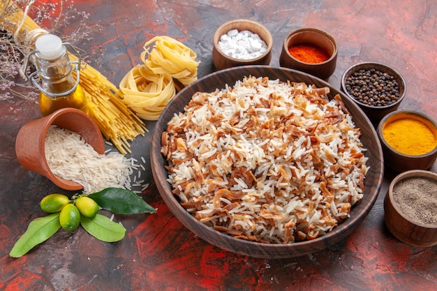 Vista dall'alto di riso cotto con condimenti su un piatto da portata con foto di superficie scura